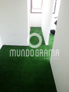 Sala comercial com piso revestido de grama sintética