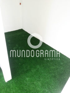 Sala comercial com piso revestido de grama sintética