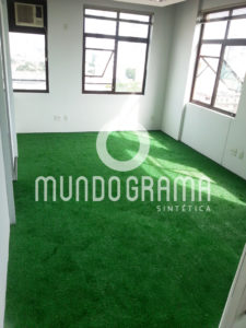 Sala comercial com piso revestido de grama sintética