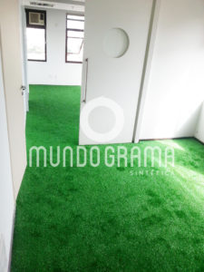 Sala comercial com piso revestido de grama sintética